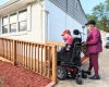 A person in a wheelchair pushed by her wife